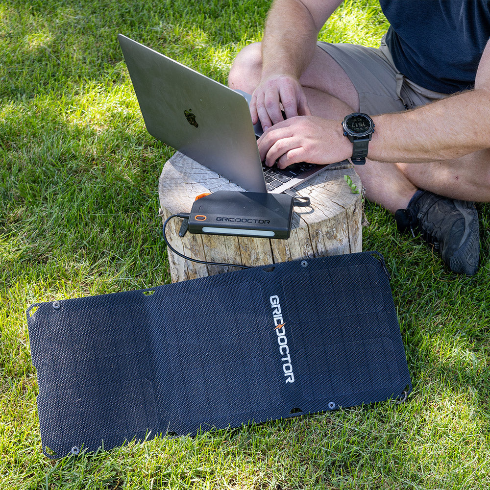 65W Power Bank plugged into the included solar panel being used to charge a laptop