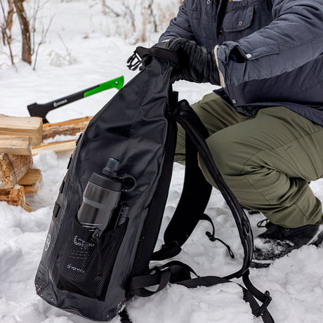 Person packing waterproof backpack in winter